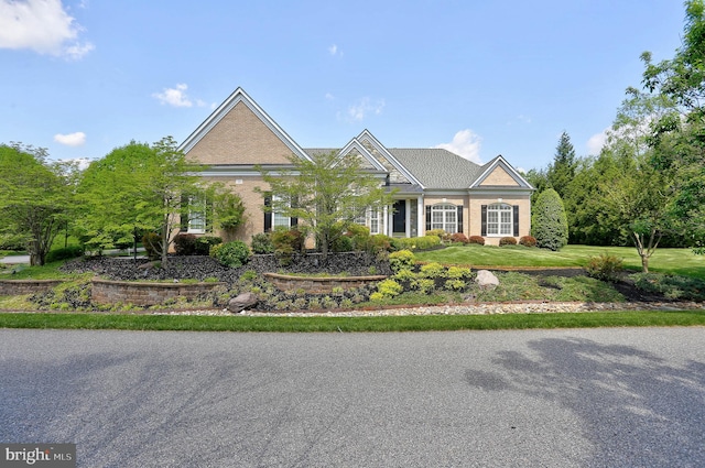 view of front of home with brick siding and a front yard