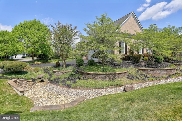 view of home's exterior with brick siding and a lawn