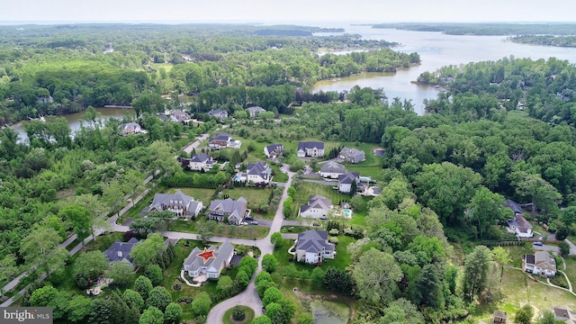 aerial view featuring a water view, a view of trees, and a residential view