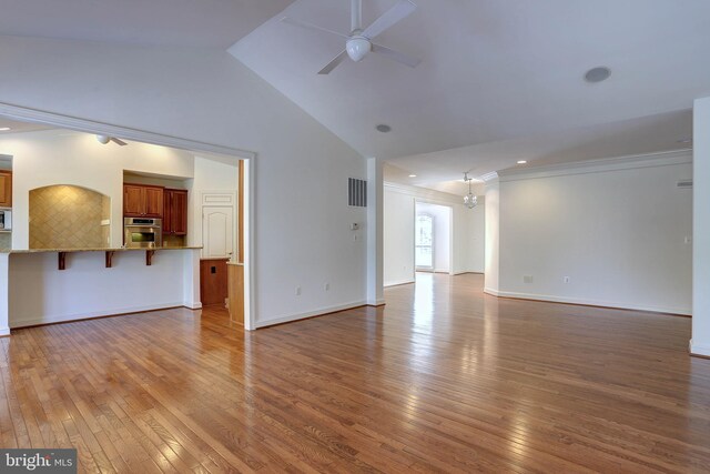 unfurnished living room featuring a ceiling fan, wood-type flooring, ornamental molding, baseboards, and high vaulted ceiling