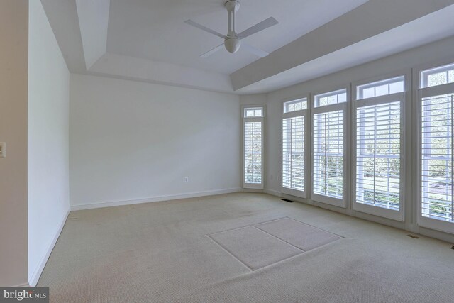 carpeted empty room featuring plenty of natural light, baseboards, and a ceiling fan