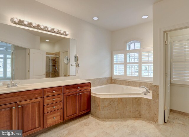 bathroom featuring a shower stall, a garden tub, and vanity