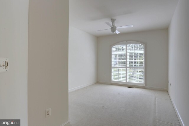 spare room with a ceiling fan, carpet, and baseboards