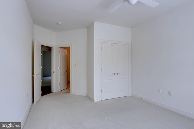 unfurnished bedroom featuring carpet floors, a closet, baseboards, and a ceiling fan