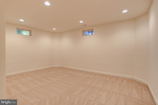 below grade area featuring recessed lighting, light carpet, and baseboards