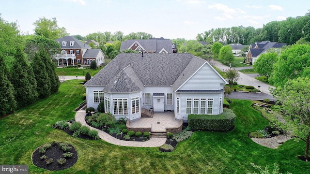 back of property featuring a patio area, a residential view, and a lawn