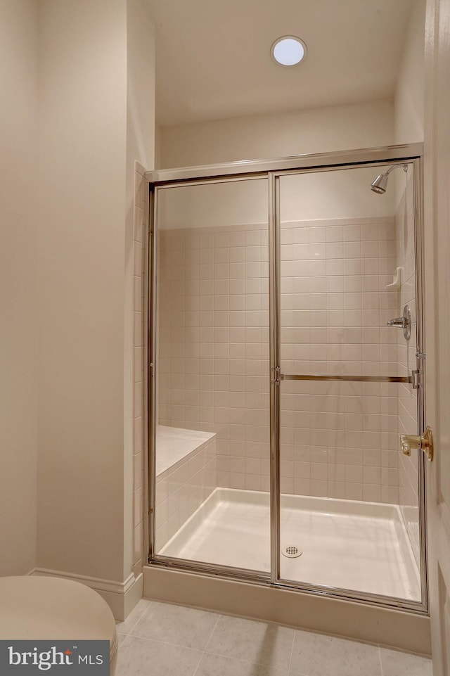 bathroom with tile patterned floors, toilet, a stall shower, and recessed lighting