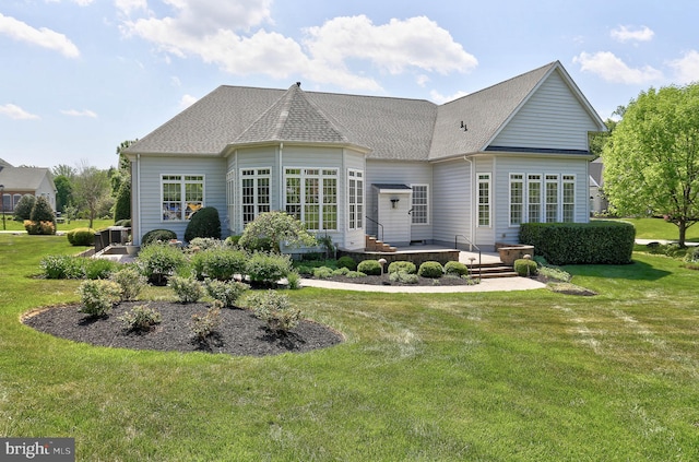 rear view of property with a yard, a patio, and roof with shingles