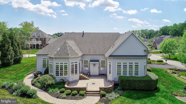 back of property featuring a yard, entry steps, a patio area, and a shingled roof