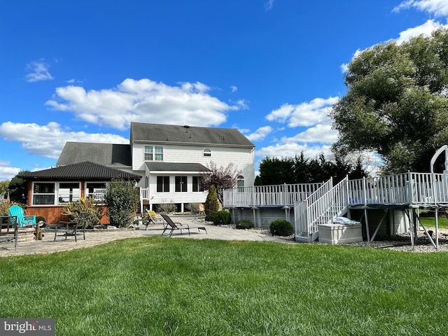 rear view of house with a yard, stairs, a patio, and a wooden deck