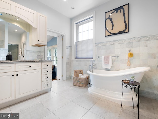 13 The Strand, New Castle, DE 19720 - full bath with tile patterned floors, tile walls, vanity, a freestanding tub, and wainscoting