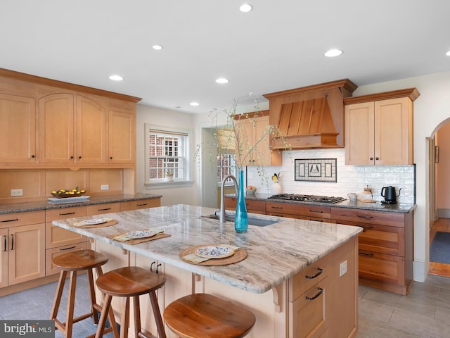 13 The Strand, New Castle, DE 19720 - kitchen with a sink, premium range hood, light brown cabinetry, arched walkways, and recessed lighting