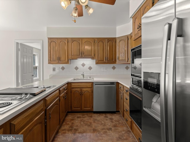 222 Springloch Rd, Silver Spring, MD 20904 - kitchen featuring stainless steel appliances, a sink, a ceiling fan, brown cabinets, and decorative backsplash