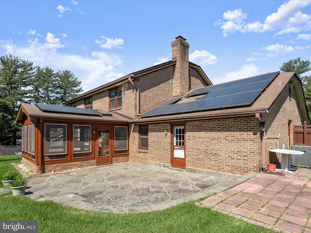 222 Springloch Rd, Silver Spring, MD 20904 - back of house featuring roof mounted solar panels, a chimney, and brick siding