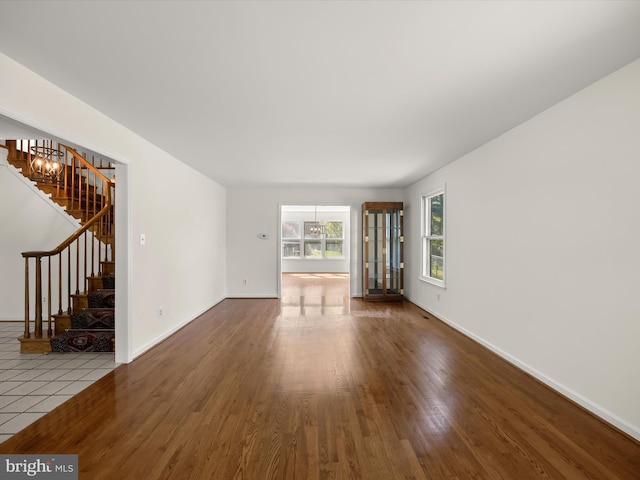 222 Springloch Rd, Silver Spring, MD 20904 - unfurnished living room featuring stairs, wood finished floors, a chandelier, and baseboards