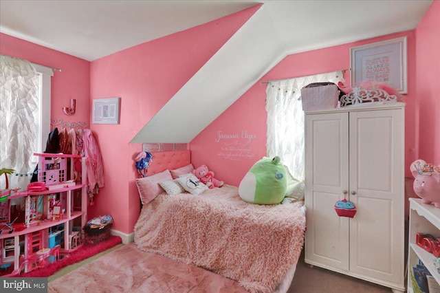 bedroom with lofted ceiling, multiple windows, and carpet flooring