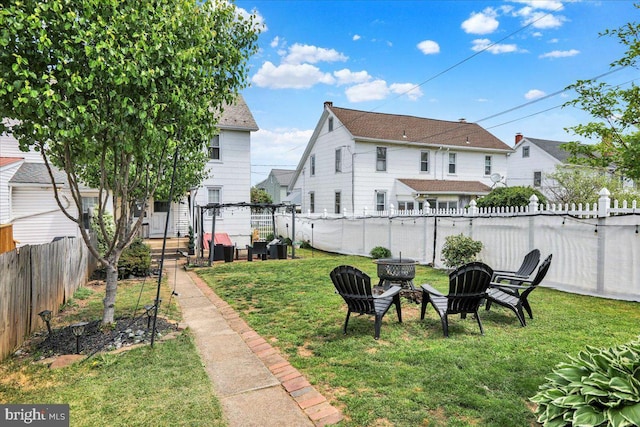 view of yard featuring a fenced backyard and a fire pit