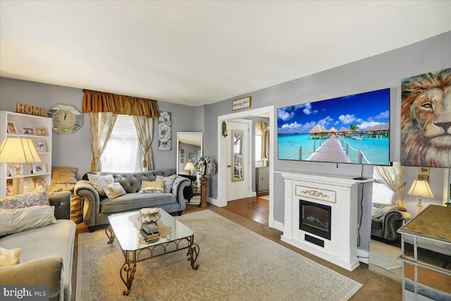 living room with baseboards and a glass covered fireplace