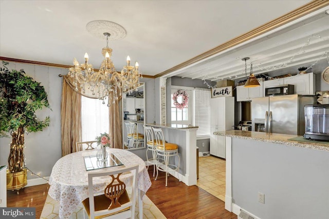 dining area with an inviting chandelier, baseboards, and wood finished floors