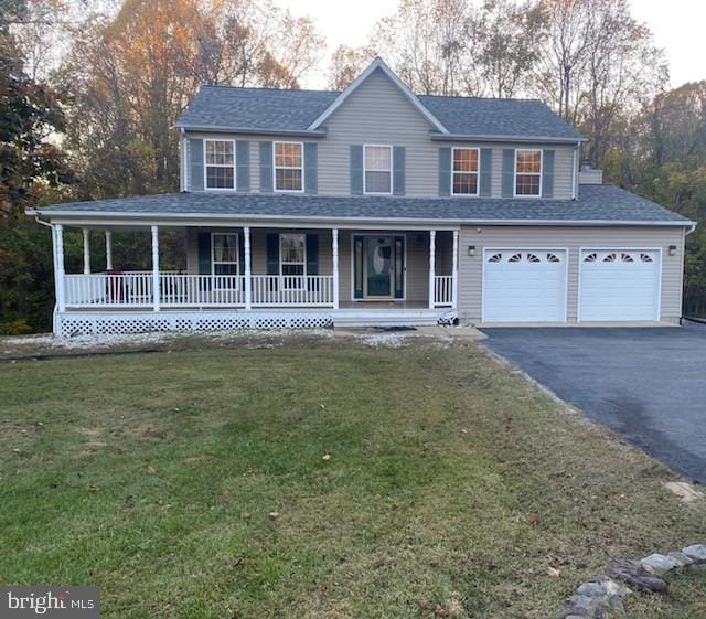 view of front of house featuring a front lawn, driveway, a shingled roof, and covered porch