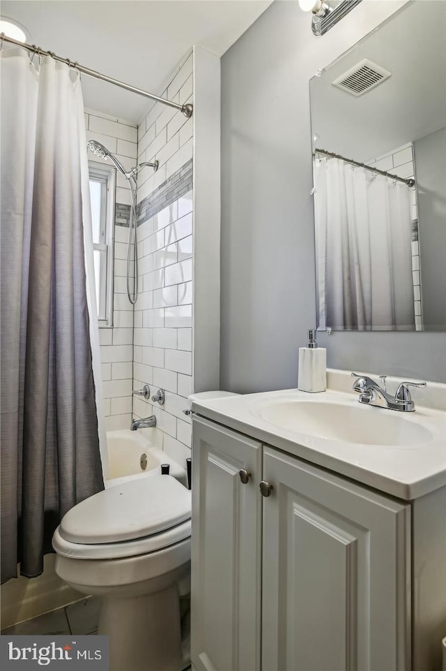 bathroom featuring toilet, vanity, visible vents, and shower / bath combo