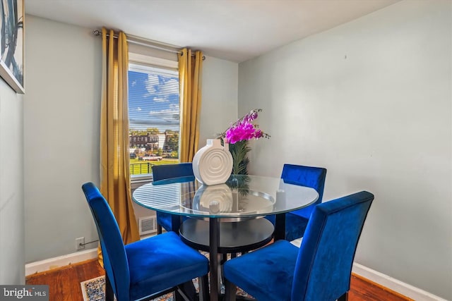 dining room with visible vents, wood finished floors, and baseboards