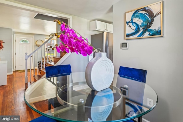 dining space featuring stairway, wood finished floors, and baseboards