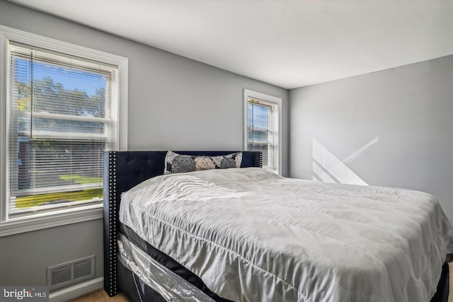 bedroom with carpet floors, baseboards, and visible vents