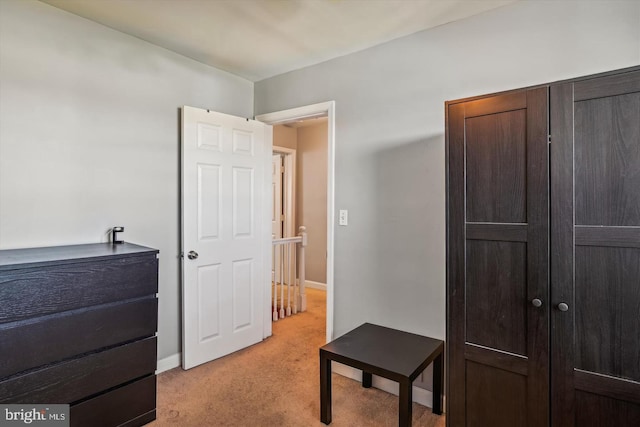 bedroom with light carpet and baseboards