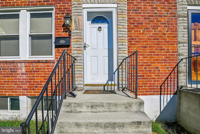 doorway to property with stone siding and brick siding