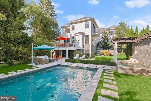 back of house featuring an outdoor hangout area, a balcony, a yard, and an outdoor pool
