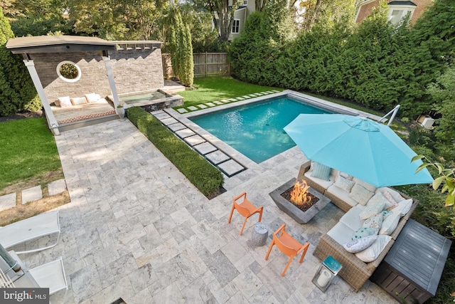 view of swimming pool featuring a fire pit, a patio, and fence