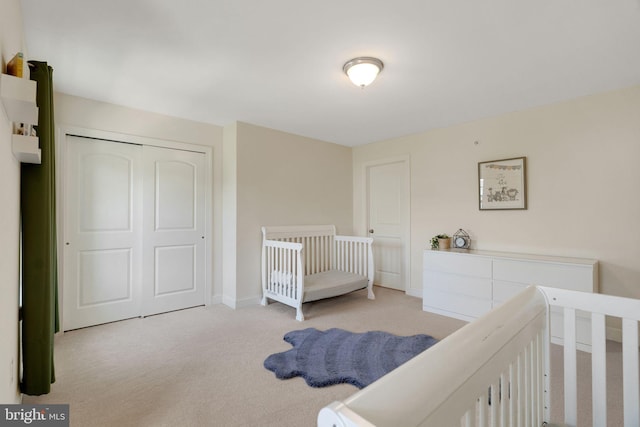 carpeted bedroom featuring a closet and baseboards