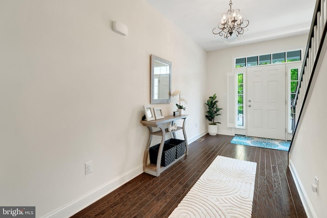 entryway featuring a chandelier, dark wood-style floors, and baseboards