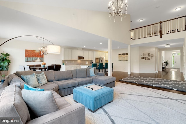 living room with a chandelier, recessed lighting, and a high ceiling