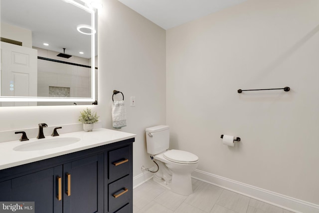 full bath with baseboards, toilet, vanity, a tile shower, and tile patterned floors