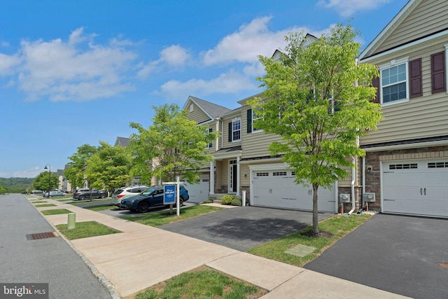 view of front of property featuring driveway, a garage, and stone siding