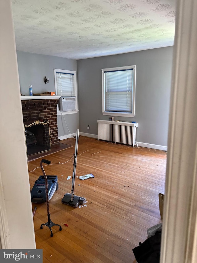 1127 45th Pl SE, Washington, DC 20019 - interior space featuring baseboards, radiator, cooling unit, hardwood / wood-style flooring, and a fireplace