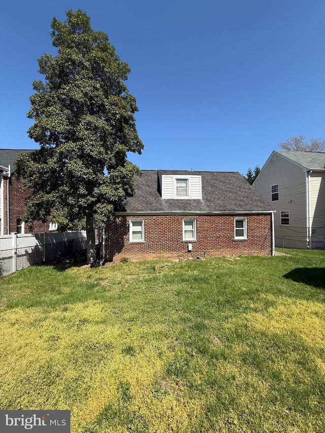 1127 45th Pl SE, Washington, DC 20019 - view of side of home with a lawn, roof with shingles, brick siding, and fence
