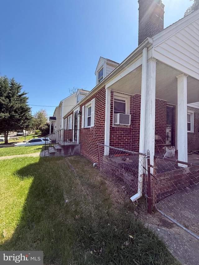 1127 45th Pl SE, Washington, DC 20019 - view of home's exterior with a yard, brick siding, a chimney, and cooling unit