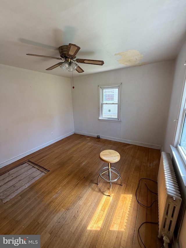 1127 45th Pl SE, Washington, DC 20019 - spare room with radiator, wood finished floors, baseboards, and ceiling fan