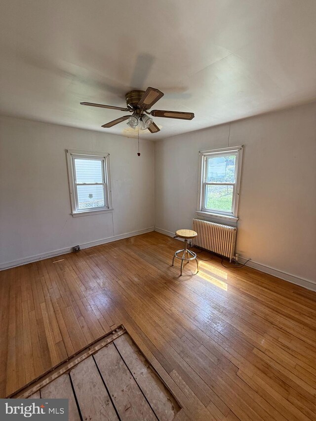 1127 45th Pl SE, Washington, DC 20019 - unfurnished room featuring hardwood / wood-style flooring, radiator, baseboards, and a wealth of natural light