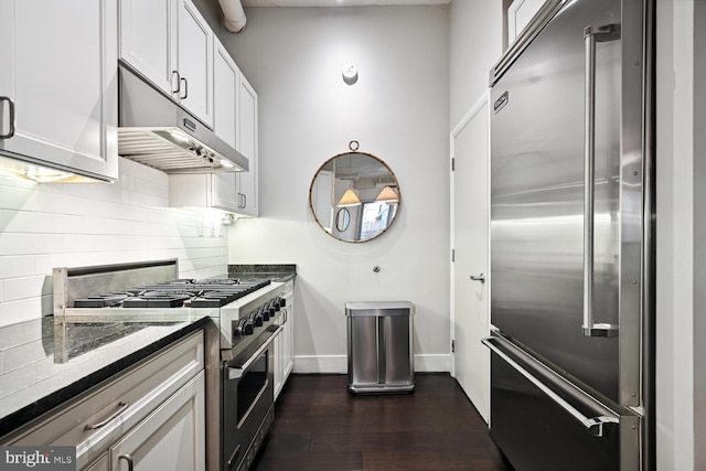 1700 Kalorama Rd NW Unit 207, Washington, DC 20009 - kitchen featuring high end appliances, under cabinet range hood, dark wood finished floors, tasteful backsplash, and dark stone countertops