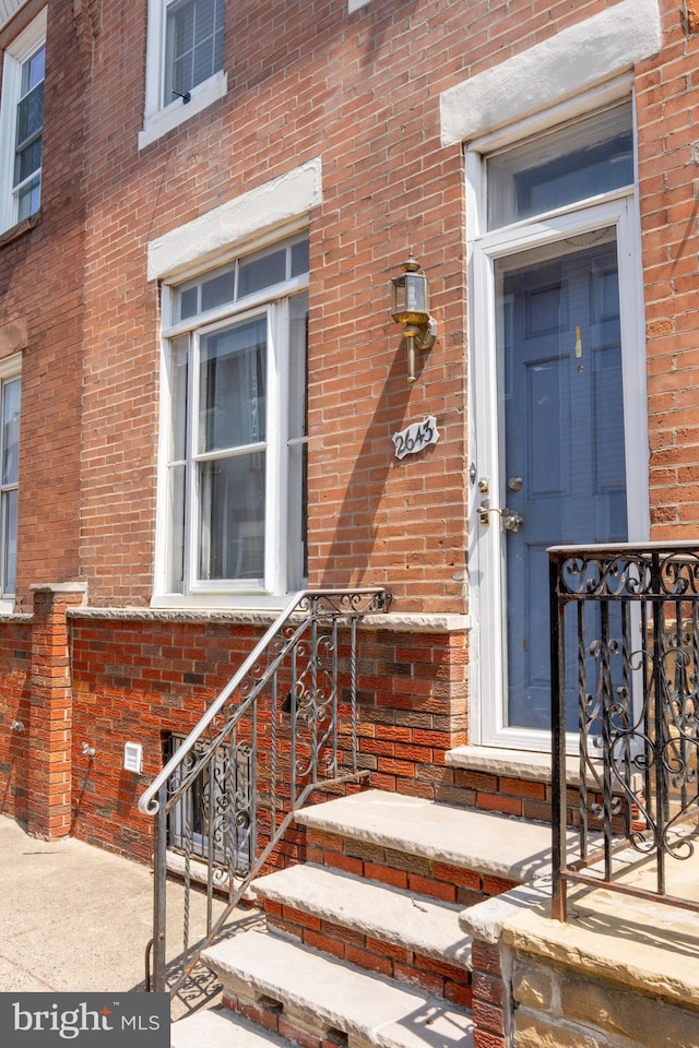 view of exterior entry with brick siding