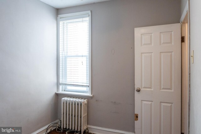 unfurnished room featuring baseboards and radiator heating unit