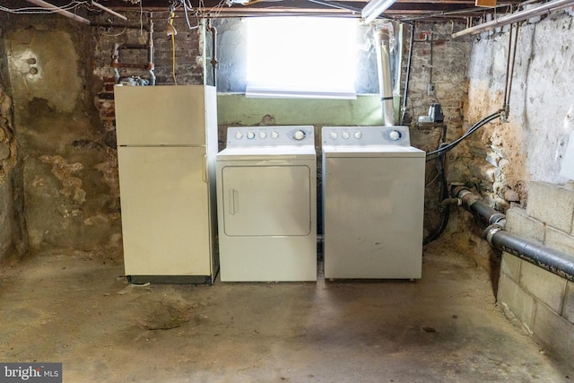 below grade area with freestanding refrigerator and washer and dryer