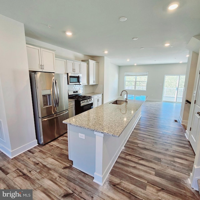 2277 Marcy Dr, Frederick, MD 21702 - kitchen with stainless steel appliances, a sink, wood finished floors, white cabinetry, and an island with sink