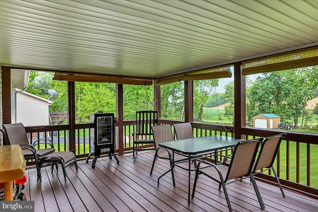 sunroom / solarium with a wooden deck, outdoor dining area, wood-type flooring, and wine cooler