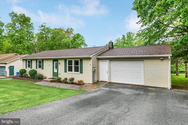 ranch-style home featuring an attached garage, driveway, a chimney, a front yard, and a shingled roof