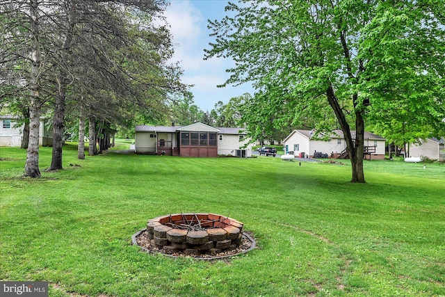 view of grassy yard featuring an outdoor fire pit